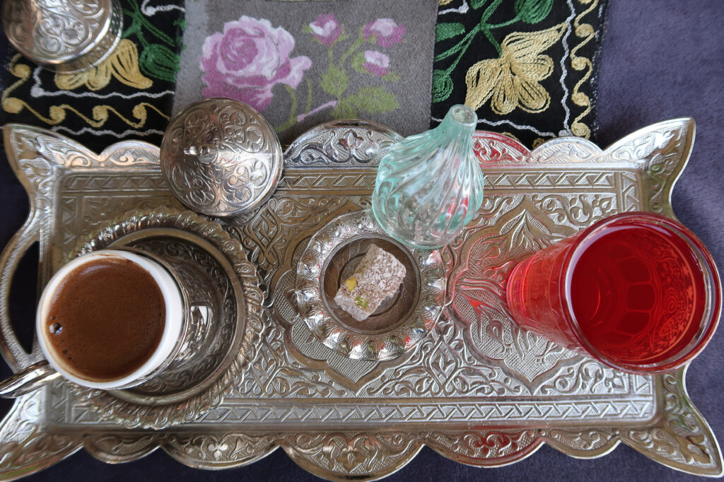 Feature image: a photo of a traditional Turkish coffee set with a silver filigree tray, coffee, juice, sugar cubes, and lokum