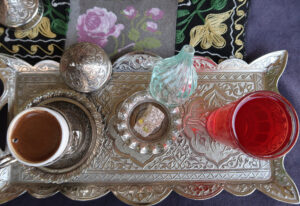 Feature image: a photo of a traditional Turkish coffee set with a silver filigree tray, coffee, juice, sugar cubes, and lokum